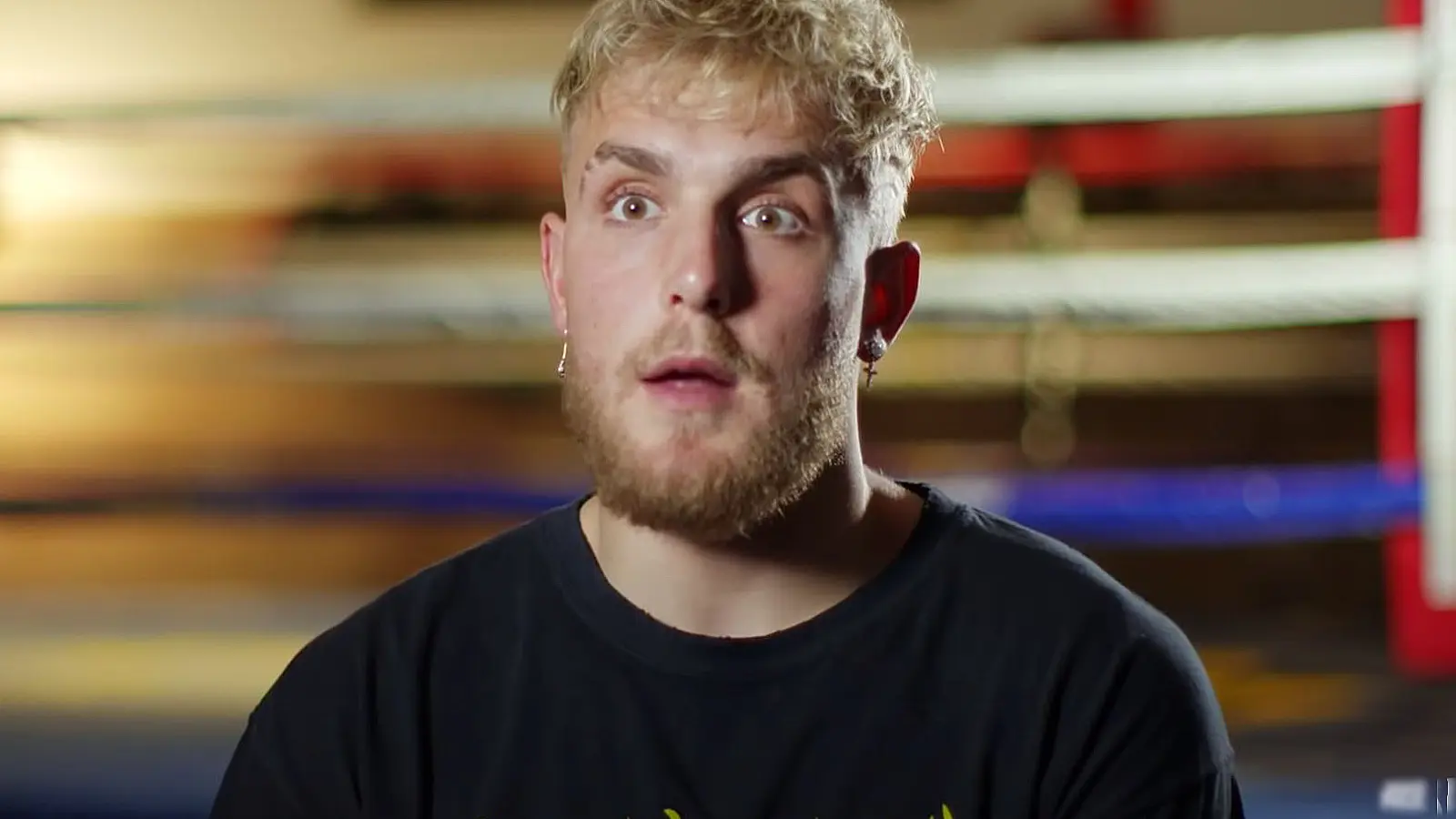 Jake Paul speaks to the camera near a boxing ring.