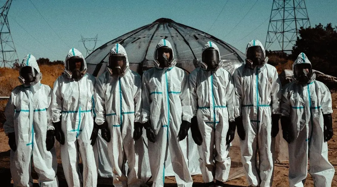 The Lab content house stand together, dressed in hazmat suits to hide their face.