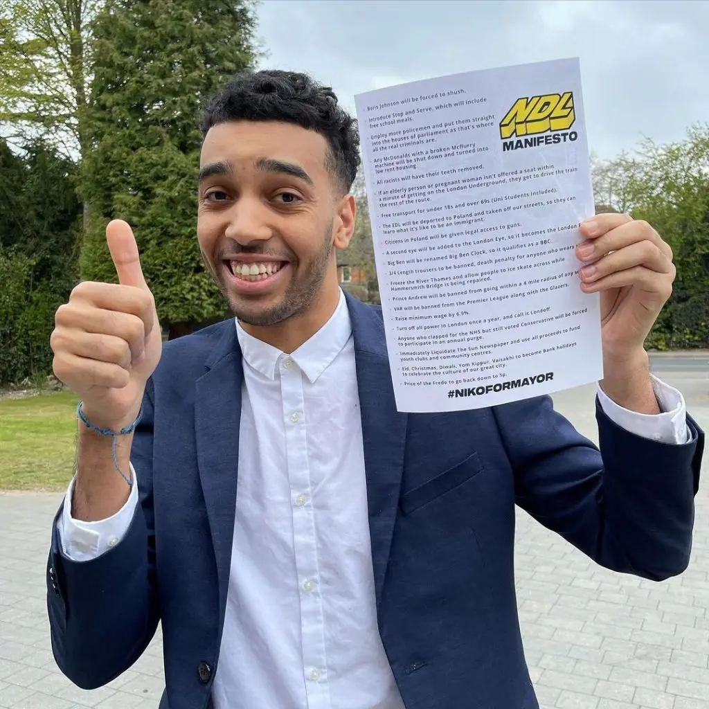 Niko Omilana posing next to his manifesto for London Mayor