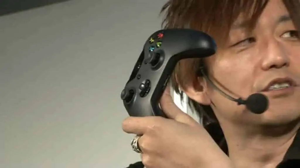 Yoshi P holds xbox controller