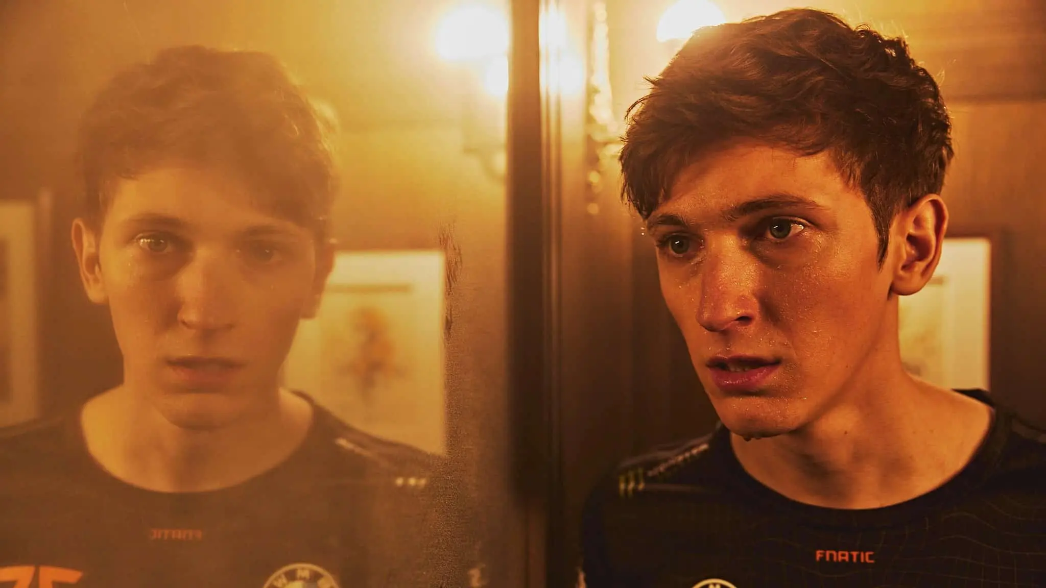 Fnatic's Boaster looks into his reflection with a concerned face.