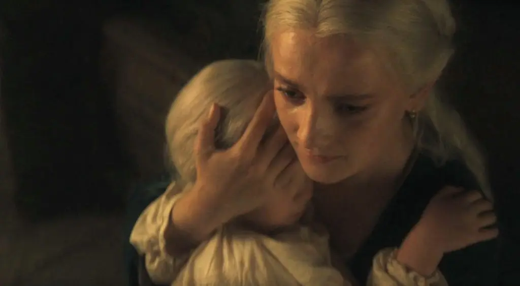 Phia Saban as Helaena holding her daughter in House of the Dragon