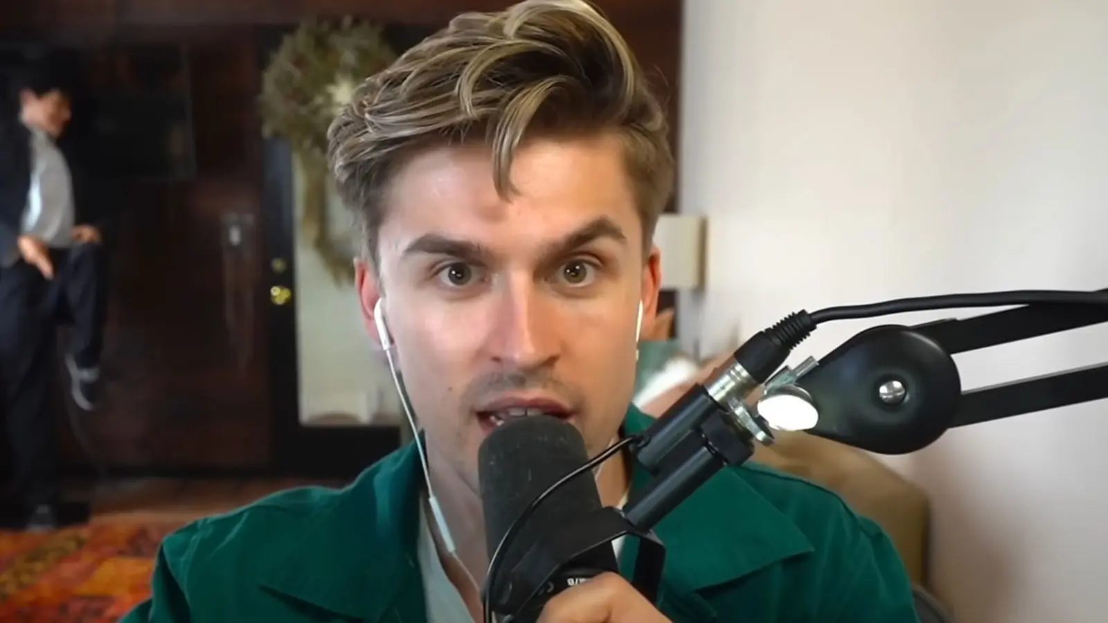 YouTube streamer Ludwig sat at his desk holding SHURE SM7B microphone