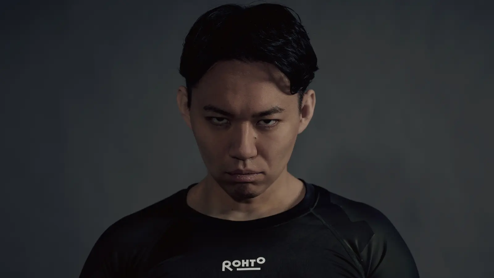 Tokido doing a murderface on a grey background