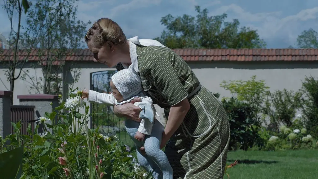 Sandra Hüller as Hedwig Hoss, holding a baby in The Zone of Interest.