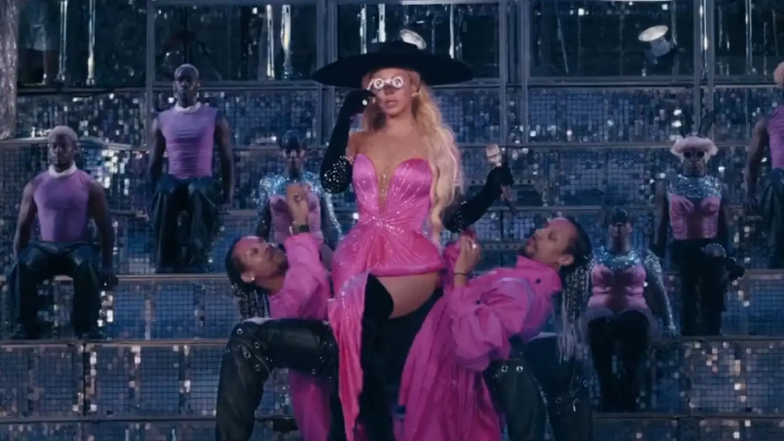 Beyonce performs in a pink outfit onstage in a concert.