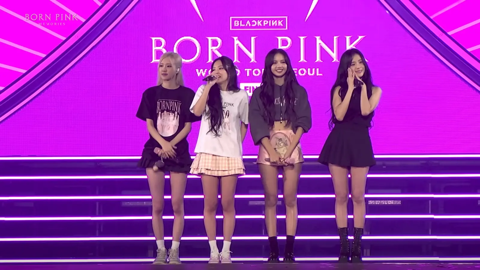 Blackpink performing onstage at a concert in front of pink backdrop