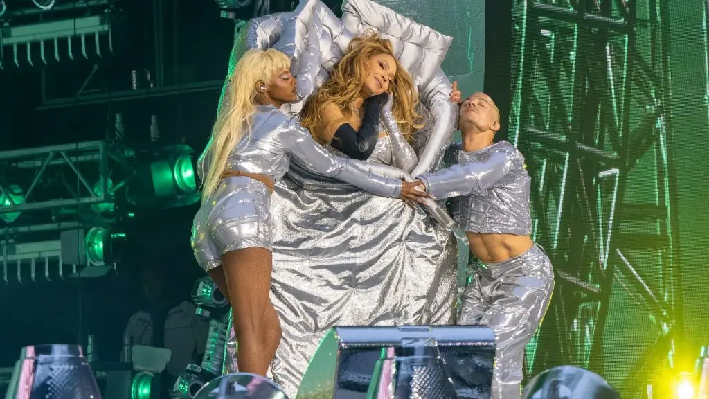 Beyonce performs onstage at a concert in front of green light