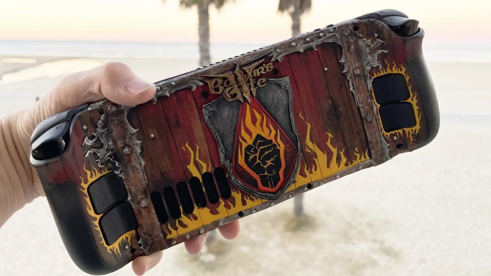 Baldur's Gate 3 Steam Deck on a beach with a hand holding it