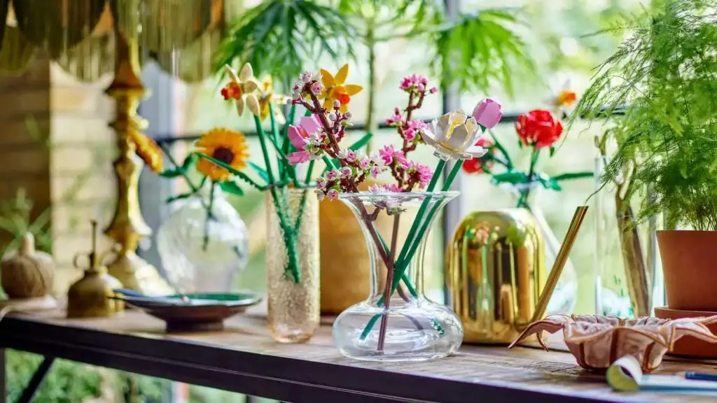 LEGO Cherry Blossoms displayed in a vase next to other flower-inspired LEGO sets.