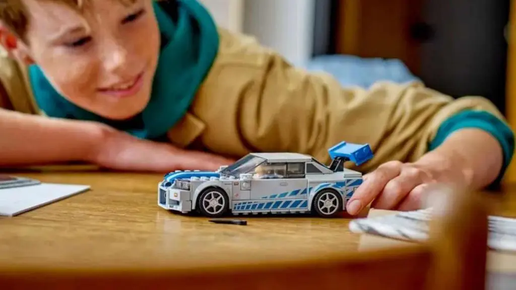 A child with their LEGO Speed Champions 2 Fast 2 Furious Nissan Skyline GT-R