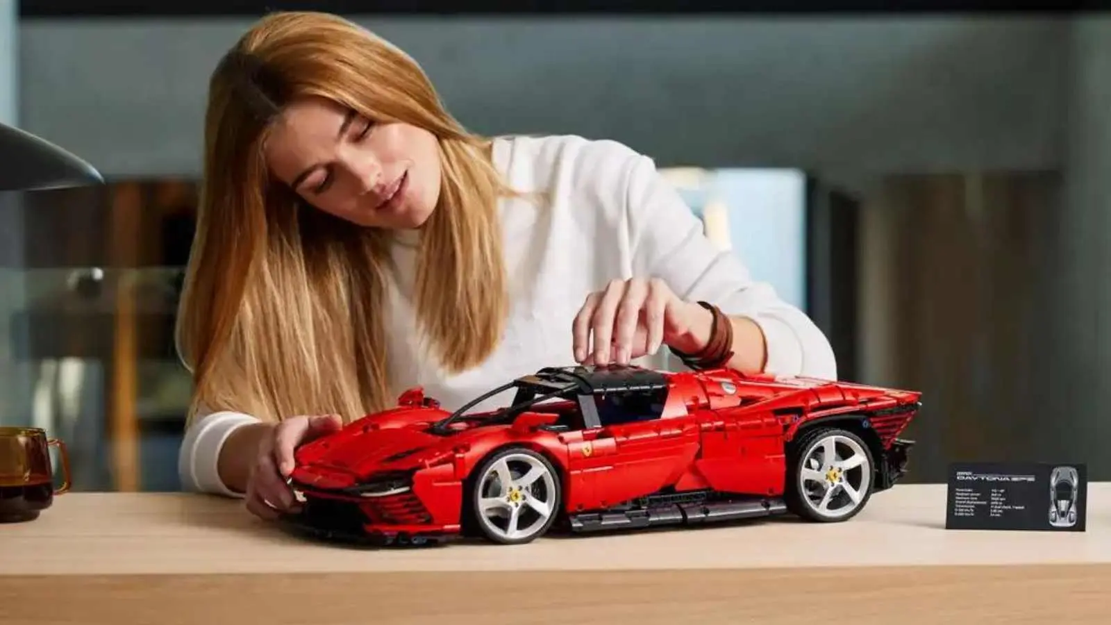 An adult admiring their LEGO Technic Ferrari Daytona SP3 set.