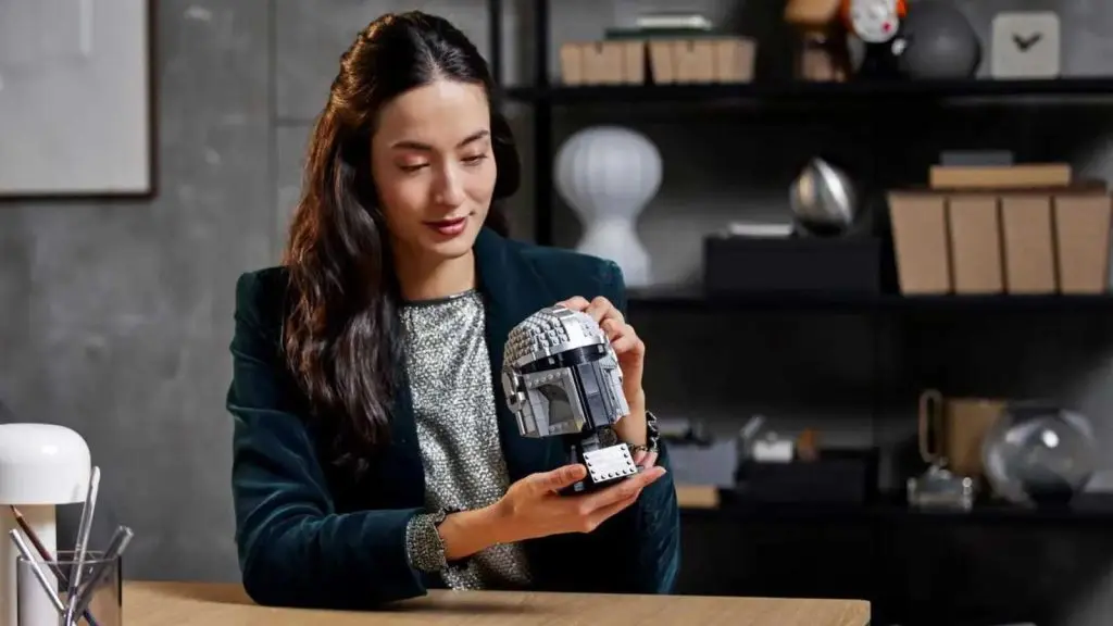 An adult admiring their LEGO-reimagined The Mandalorian's Helmet.