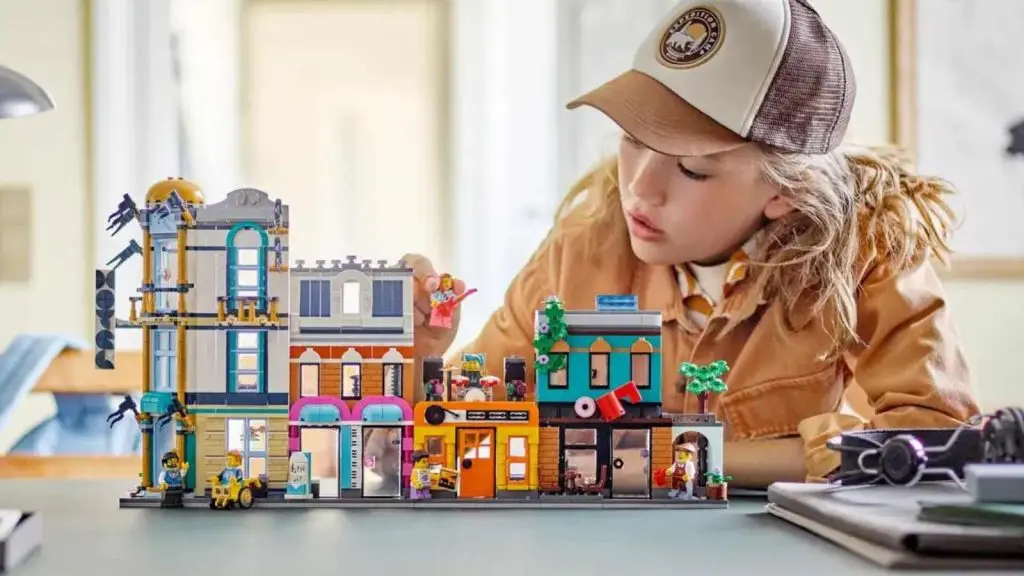 A child admiring their LEGO Creator 3in1 Main Street set