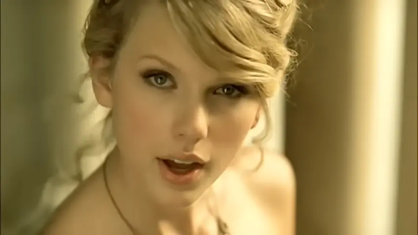 Taylor Swift with her hair pinned back and wearing a ball gown