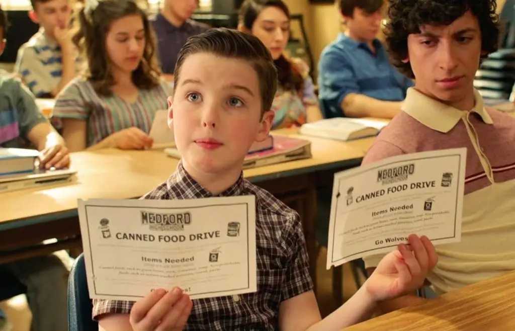 Sheldon Cooper holding up two pieces of paper at Medford High School