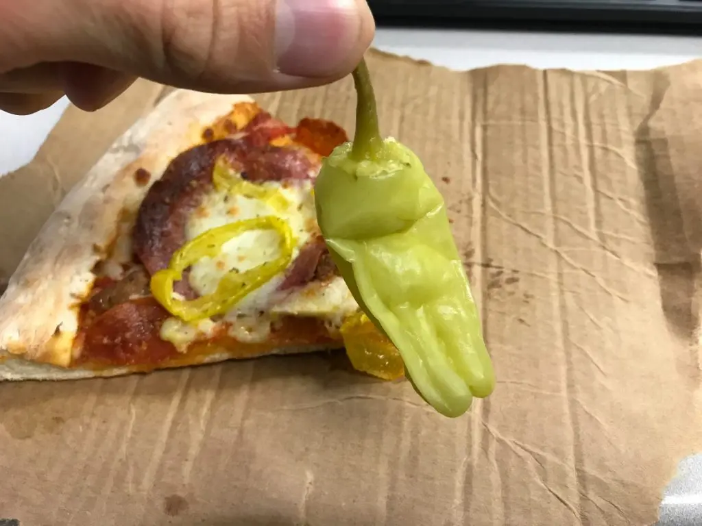 a customer holding a banana pepper