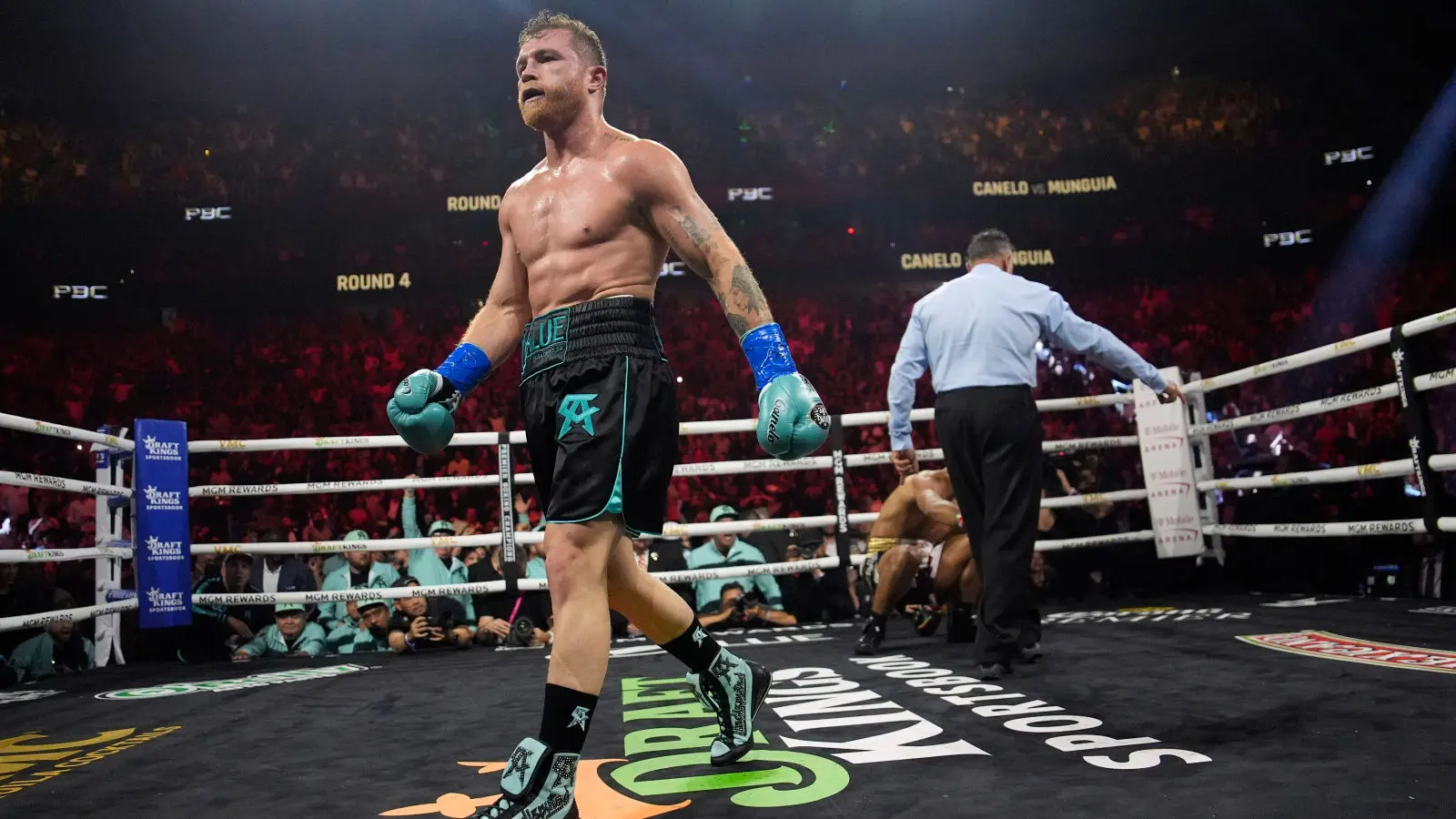 Canelo Alvarez walks towards the camera after knocking down Jaime Munguia