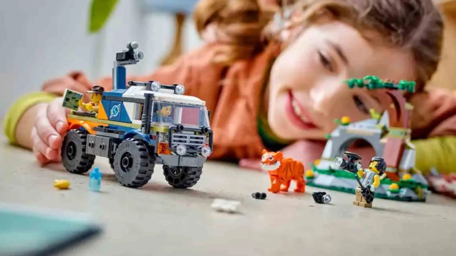 A child with their LEGO City Off-Road Truck