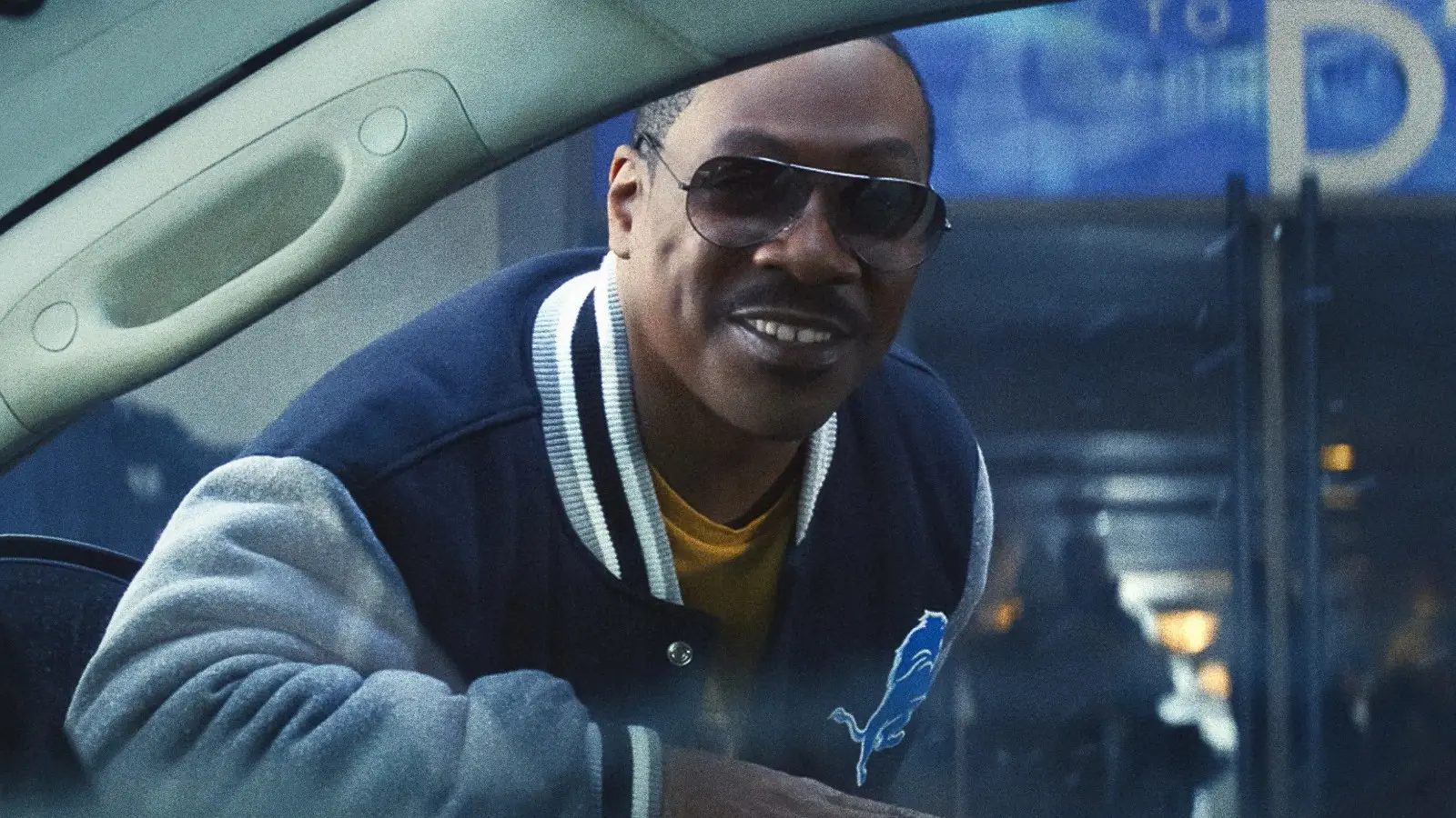 Eddie Murphy leaning through a car window in Beverly Hills Cop 4.