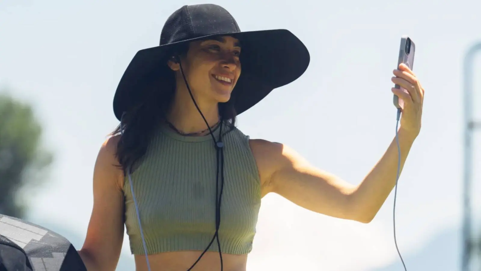 Promotional image from the EcoFlow website of a model using the Power Hat to charge their smartphone.