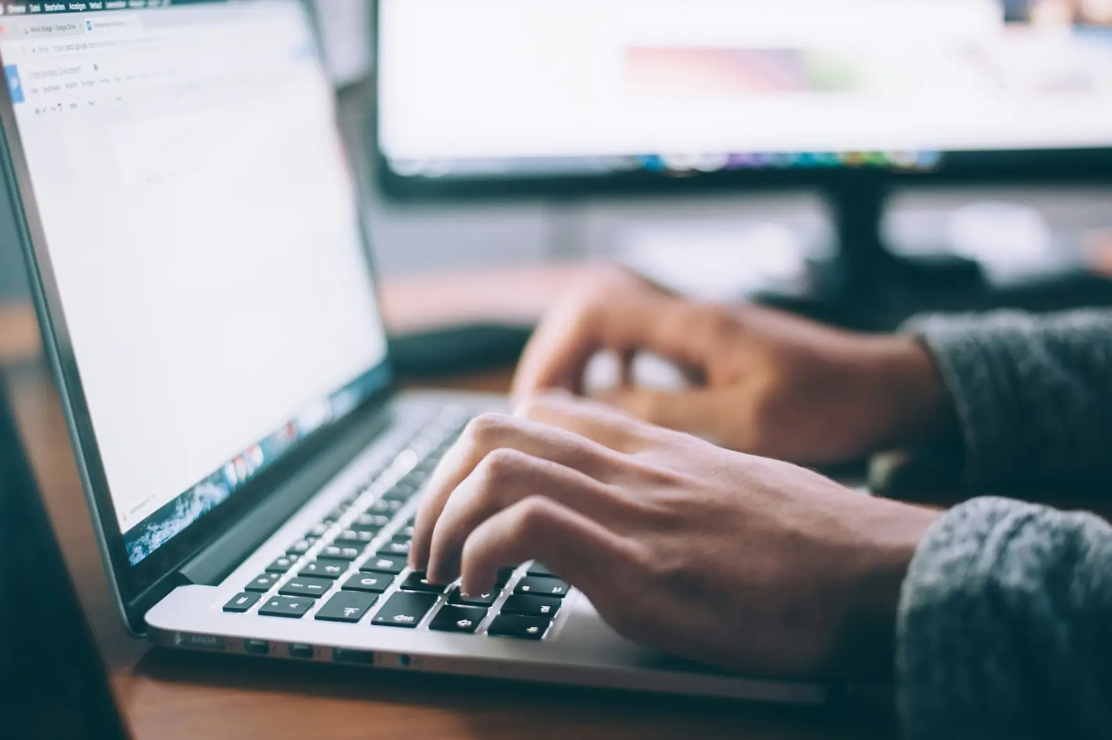 Stock image of person writing on a laptop