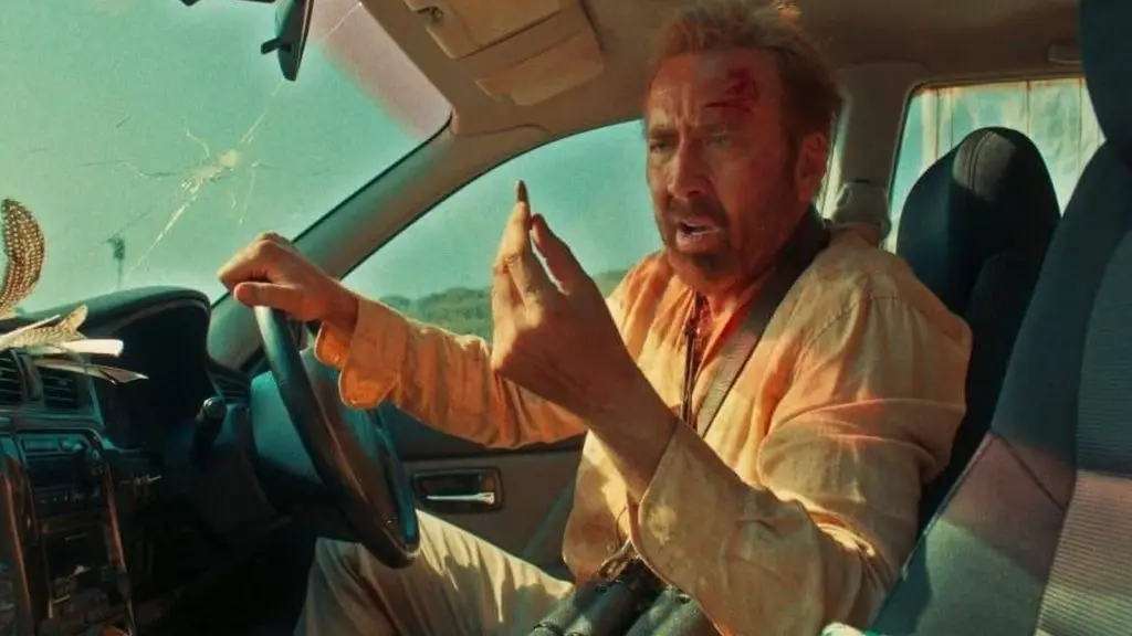 Nicolas Cage holding a bullet in The Surfer.