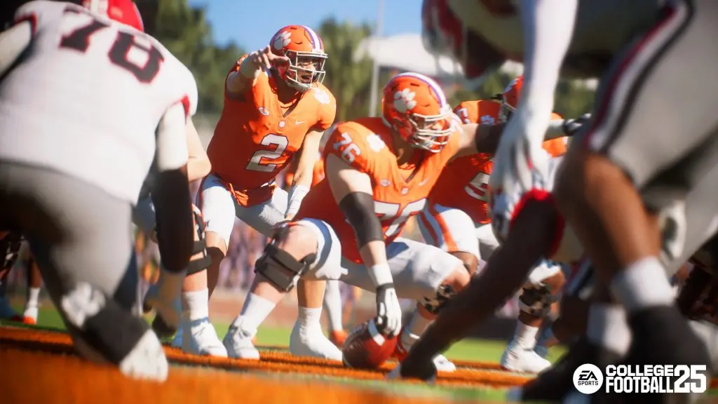 Clemson players in orange jerseys getting ready to hike the ball