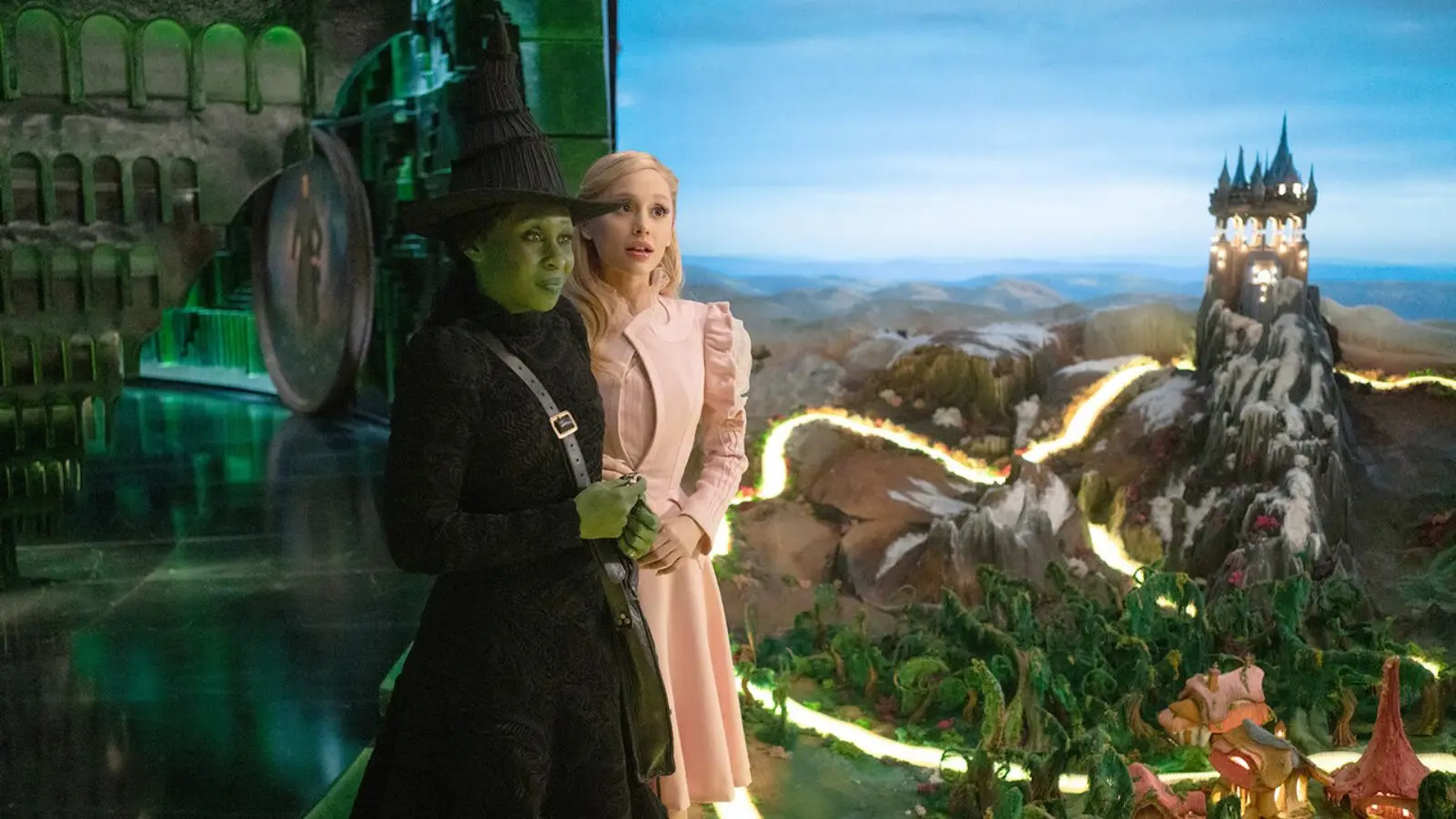 Elphaba and Glinda look over a toy version of Oz in Wicked movie