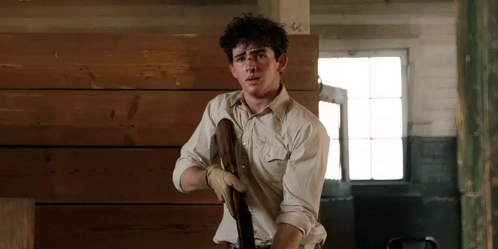 Finn Little as Carter, holding a gun in Yellowstone