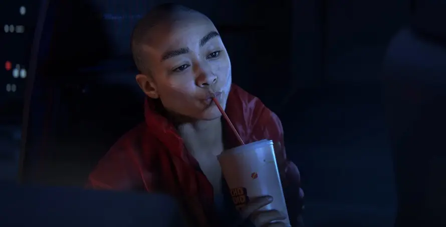 Intergalactic's main character sips on a drink.