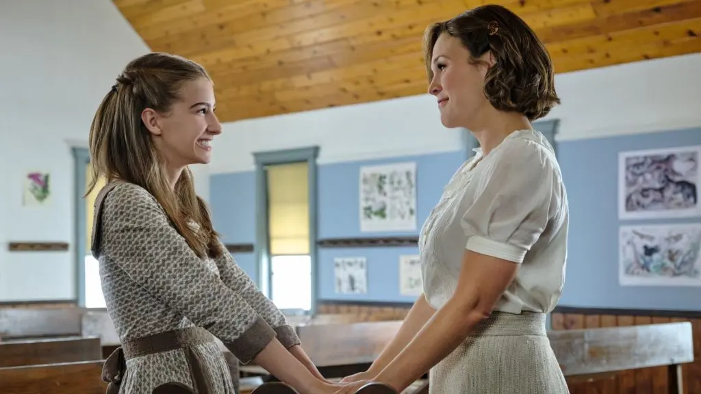 Elizabeth holds a young girl's hands in When Calls the Heart