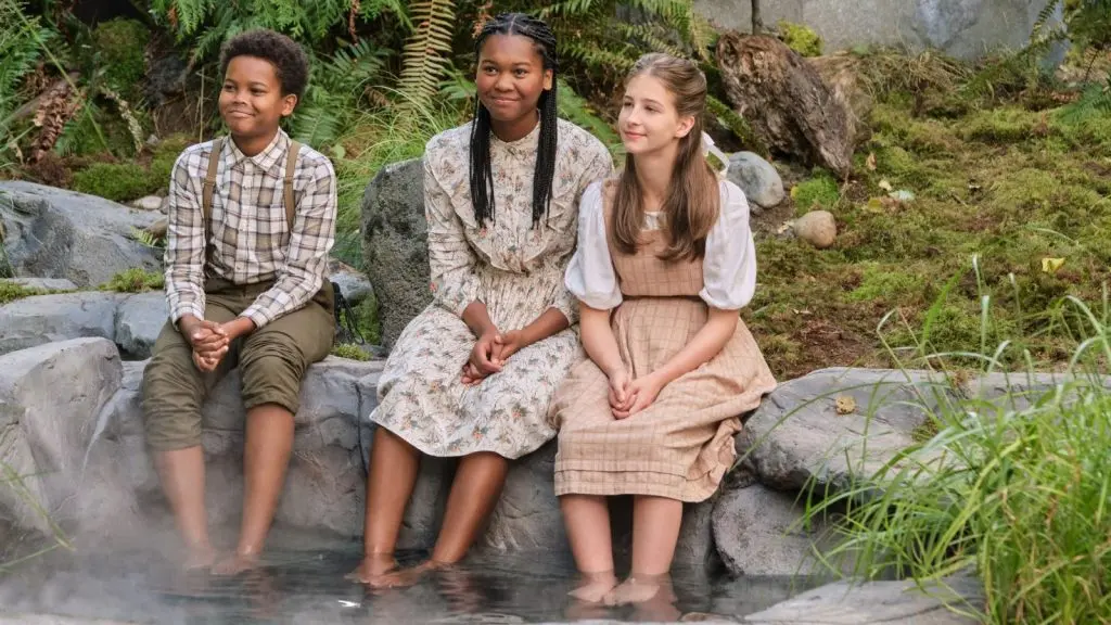 A group of children paddle their feet in hot springs in When Calls the Heart