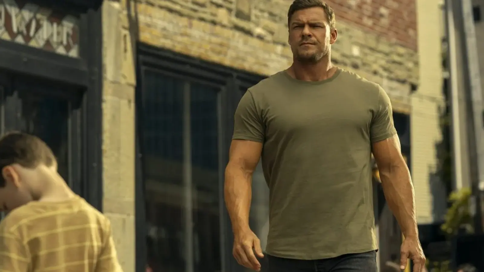 Alan Ritchson in a tight t-shirt in the opening episode of Reacher Season 3 Episode 1.