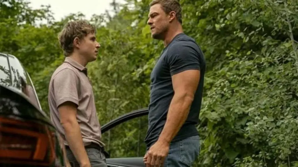 Johnny Berchtold speaking to Alan Ritchson in Reacher Season 3.