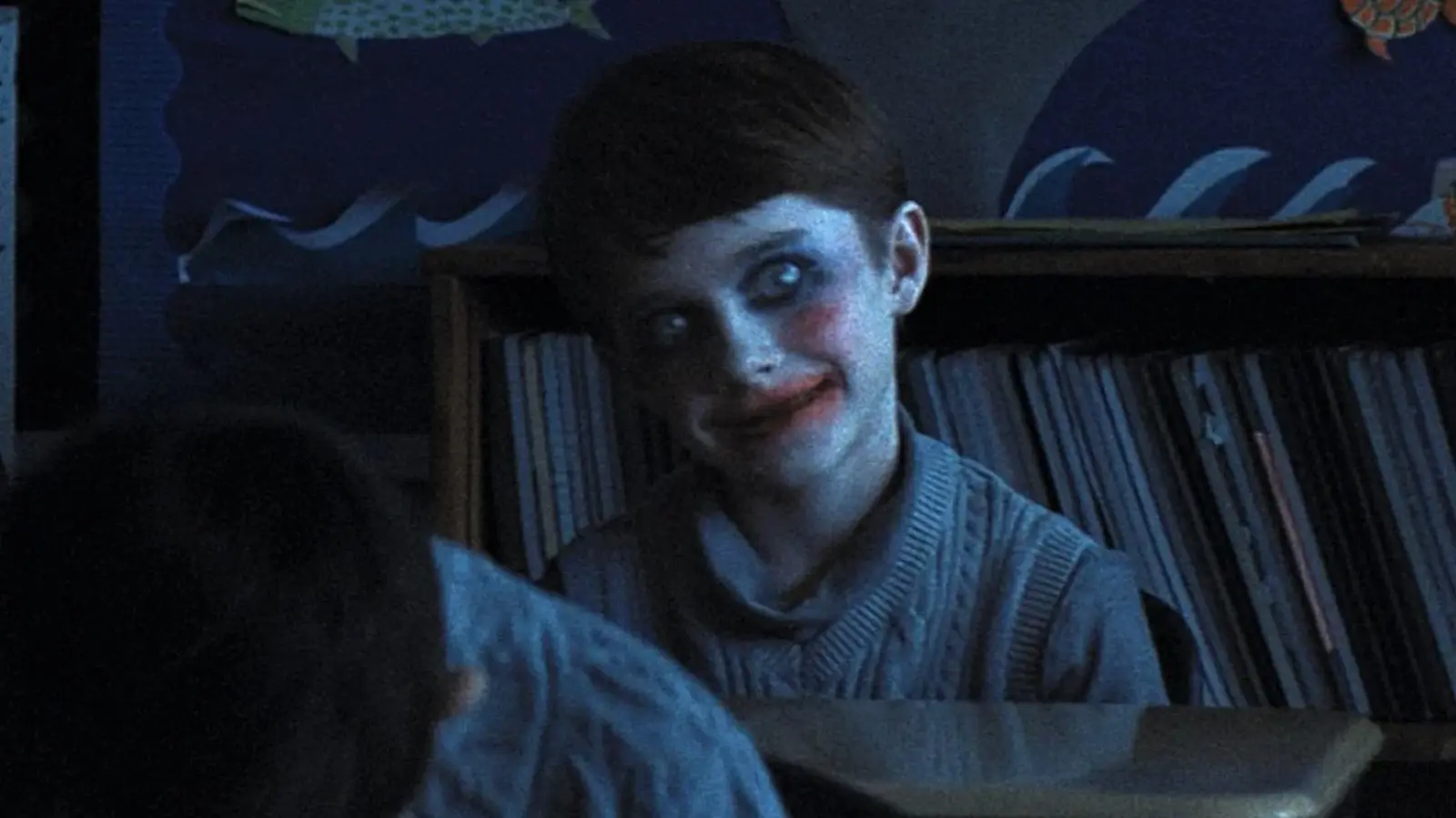 A kid with a scary smiling face in Weapons